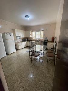 a kitchen with a glass table and chairs in it at Hostel Casarão SV in São Vicente