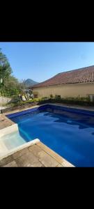 a large blue swimming pool next to a building at Hostel Casarão SV in São Vicente