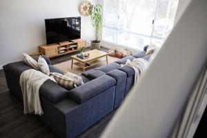 a living room with a blue couch and a tv at Water's Edge 4x4 Townhouse in Falcon
