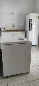 a kitchen with a white refrigerator and a counter at Edícula Caramano in Jaú
