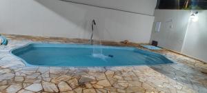 a swimming pool with a water fountain in a room at Edícula Caramano in Jaú