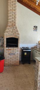 a brick oven in a kitchen with a stove at Edícula Caramano in Jaú