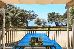 a blue table on a balcony with a view of the ocean at Water's Edge 4x4 Townhouse in Falcon