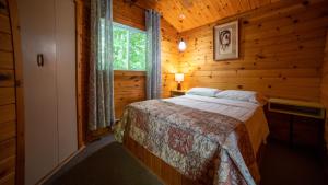 a bedroom with a bed in a wooden cabin at Stunning Lakeview Muskoka Pier 100 Resort in Port Carling