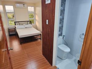 ein Badezimmer mit Toilette und ein Bett in einem Zimmer in der Unterkunft Kuyang's Place in Bulala