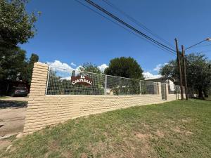 a fence with a sign on it in a yard at Casa El Chaparral Villa Dolores, Traslasierra 3 in Piedra Pintada +6 photos