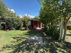 a yard with a house with a tree at Casa El Chaparral Villa Dolores, Traslasierra 3 in Piedra Pintada