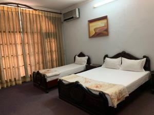 a bedroom with two beds and a window at Kim Anh Hotel in Hanoi