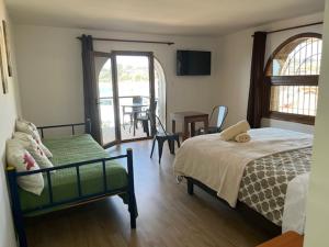 a bedroom with a bed and a balcony with a table at Costanera240 in El Quisco
