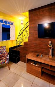 a living room with a tv and a couch and a table at Canto da Lua in Lençóis