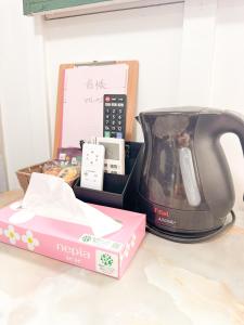 a tea kettle and a box on a counter at ゲストハウスまるとく in Yoron