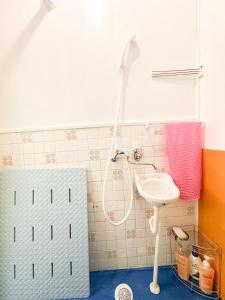 a bathroom with a shower and a sink at ゲストハウスまるとく in Yoron