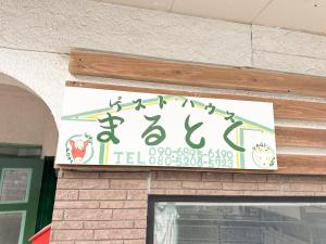 a sign on the side of a building at ゲストハウスまるとく in Yoron +13 photos