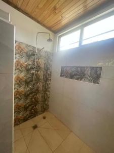 a bathroom with a shower and a wall with a mural at Havaii Spot Huahine in HUH