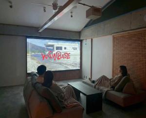 a group of people watching a video game on a tv at スターハウス in Otsu