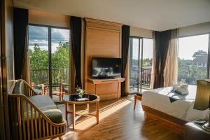 a hotel room with a bed and a television at W1Bangkoknoi Hotel in Nonthaburi