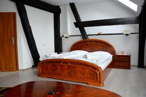 a bedroom with a wooden bed and a table at Agrotur-Maya in Gorzyca