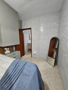 a bedroom with a bed and a cabinet and a kitchen at Brisa Do Mar in Saquarema