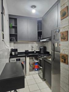 a kitchen with stainless steel appliances and gray cabinets at Brisa Do Mar in Saquarema