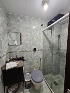 a bathroom with a shower and a toilet and a sink at Brisa Do Mar in Saquarema +2 photos