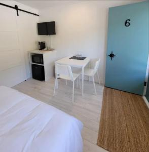 a room with a white table and chairs and a door at En Route Vers l'Infini in Perce