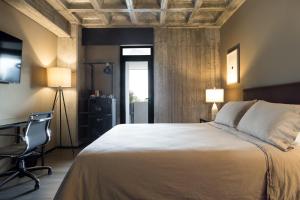 a bedroom with a bed and a desk and a chair at Bellwort Hotel in Guadalajara