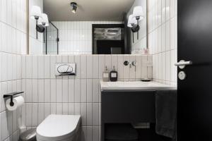 a white bathroom with a toilet and a sink at Bellwort Hotel in Guadalajara +51 photos