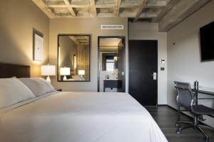 a bedroom with a bed and a desk and a chair at Bellwort Hotel in Guadalajara
