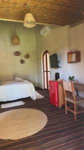 a bedroom with a bed and a tv and a chair at Casa Kaûma in Corumbau