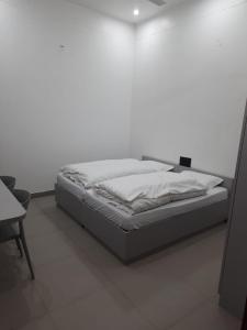a bed in a room with a white wall at Saran Homestay in Agra