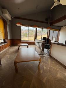 a living room with a table on a wooden floor at ゲストハウスルスティゲス in Kijimadaira +12 photos