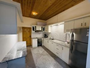 a kitchen with white cabinets and a black refrigerator at Lone Star Residence in Jaffna