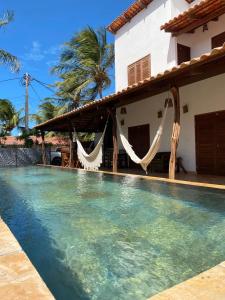 a villa with a swimming pool in front of a house at Casa Nossa Preá in Prea