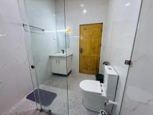 a bathroom with a toilet and a sink and a door at Lone Star Residence in Jaffna +35 photos