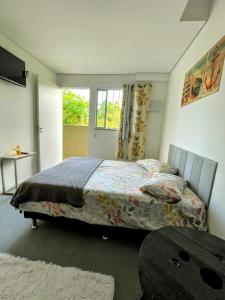 a bedroom with a bed and a table and a window at Pousada Ideal Guarujá - Estúdios Família & Quartos in Guarujá