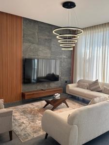 a living room with two couches and a television at Altara Villa's in Ḩayl Yaman