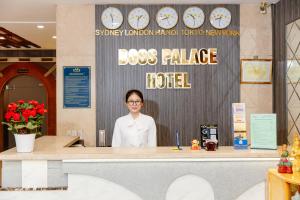 a woman standing behind a counter in aboss palace hotel at Boss Palace Hotel in Ho Chi Minh City