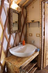 La salle de bains est pourvue d'un lavabo blanc et d'un miroir. dans l'établissement Glamping il Sole, à Civitella Marittima