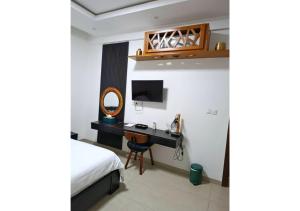 a bedroom with a bed and a desk with a mirror at Aviya - Studio meublé avec chambre et Séjour in Dakar
