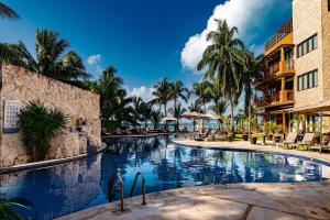 a swimming pool at a resort with palm trees at Esplendor by Wyndham Isla Mujeres Boutique All Inclusive in Isla Mujeres