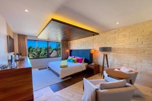 a bedroom with a bed and a living room at Esplendor by Wyndham Isla Mujeres Boutique All Inclusive in Isla Mujeres