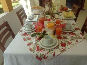a table with a table cloth with cups and plates of food at Hotel blue Ocean 3 in Parnamirim