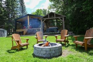 a group of chairs sitting around a fire pit in a yard at Refuge du Kodiak BORD DE L EAU in Sainte-Germaine-du-Lac-Etchemin