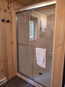 a shower with a glass door in a bathroom at Refuge du Kodiak BORD DE L EAU in Sainte-Germaine-du-Lac-Etchemin +39 photos