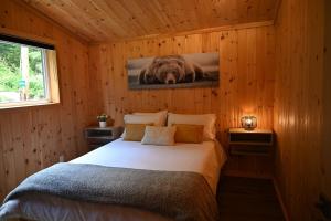 a bedroom with a bed with a picture of a bear on the wall at Refuge du Kodiak BORD DE L EAU in Sainte-Germaine-du-Lac-Etchemin