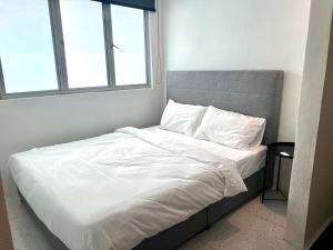 a bed with white sheets and pillows in a bedroom at Casa for 8 ipoh Central Pet Allowed in Ipoh
