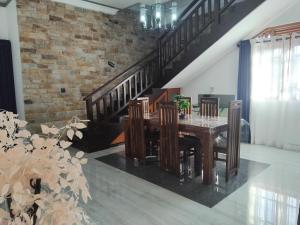 a dining room with a table and a brick wall at SAS Villa in Ahungalla