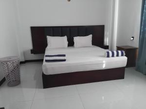 a bedroom with a large bed with two pillows at SAS Villa in Ahungalla