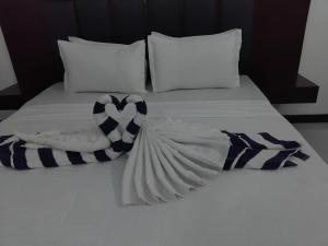 a white bed with blue and white blankets and pillows at SAS Villa in Ahungalla