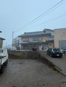 a house with a car parked in a parking lot at Kamakura in Iiyama